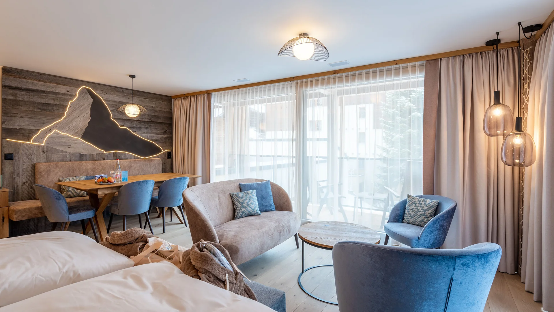 Zimmer, Appartements & Suiten - Resort La Ginabelle Zermatt Modern eingerichtetes Hotelzimmer mit Sitzbereich und großem Fenster