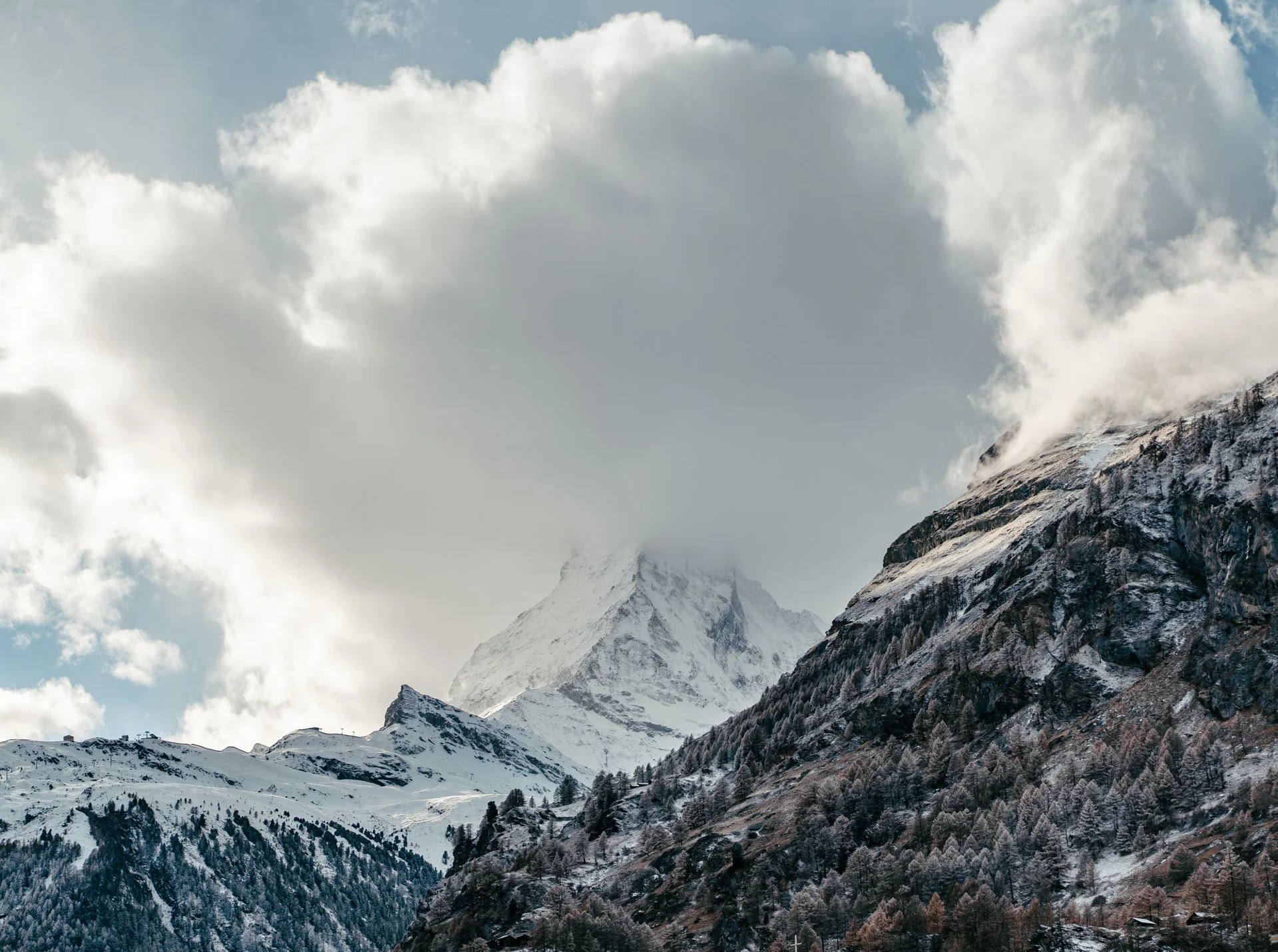 Skifahren auf dem Matterhorn - Resort La Ginabelle Zermatt Schneebedeckter Berggipfel teilweise von Wolken bedeckt