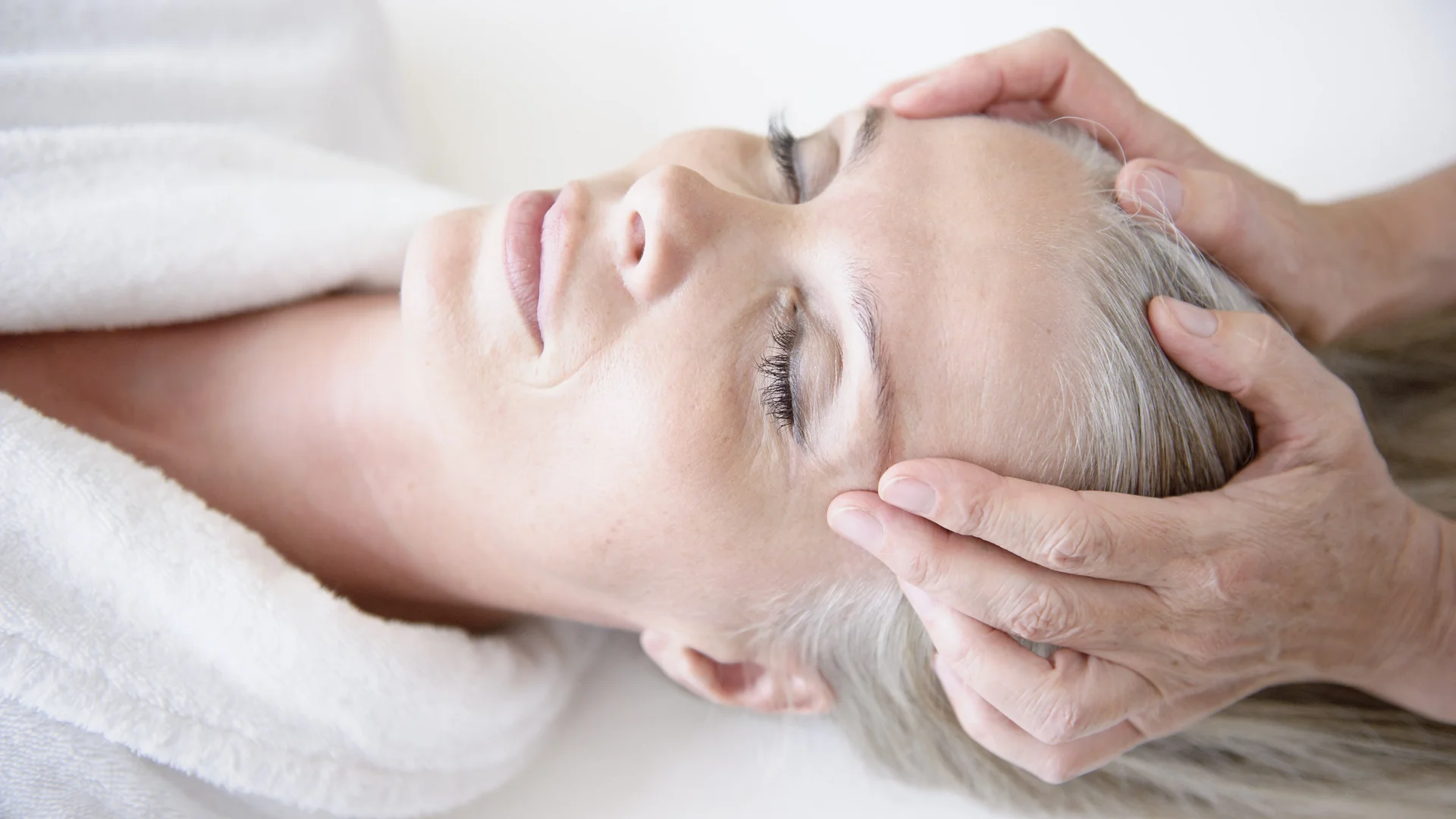 Wellnesshotel in Zermatt | GinaSPA im Resort La Ginabelle Eine entspannte Frau erhält eine Kopfmassage.