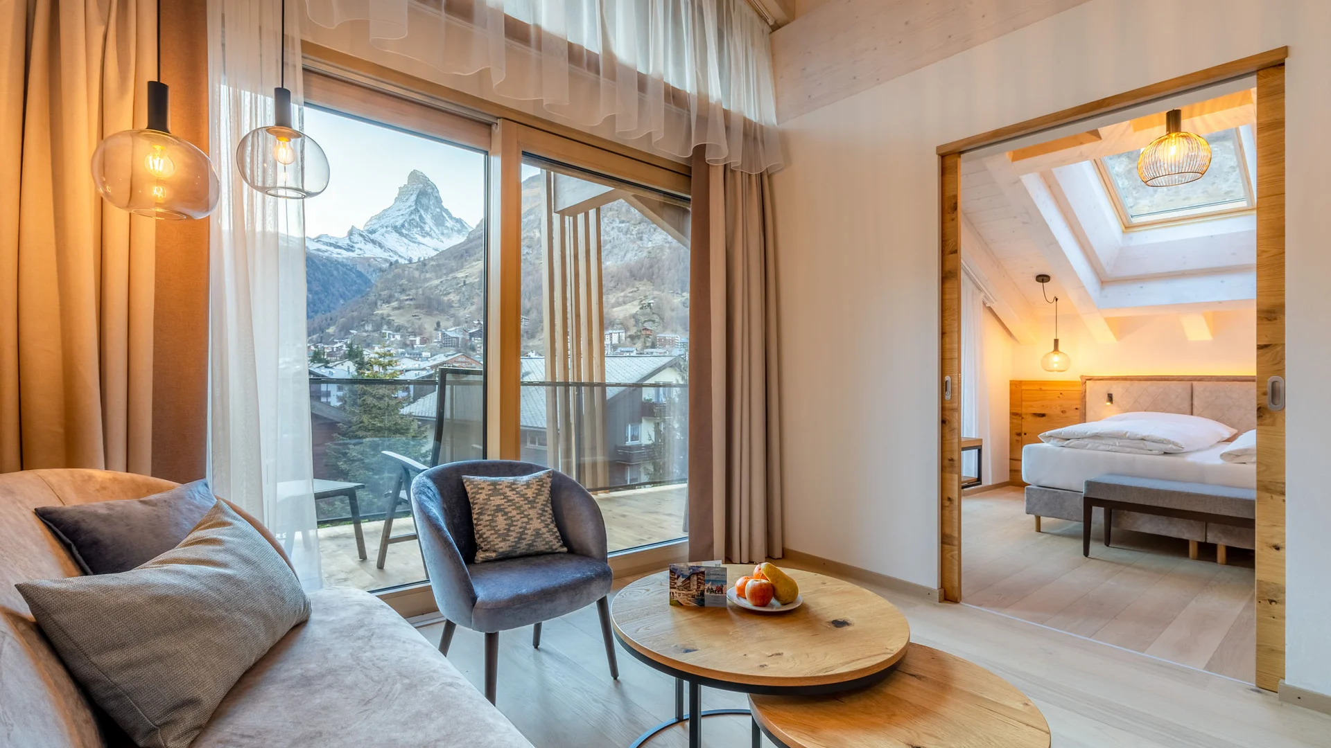 Resort La Ginabelle Zermatt: Ihr 4*S Wellnessresort in Zermatt Gemütliches Wohnzimmer mit Bergblick und angrenzendem Schlafzimmer