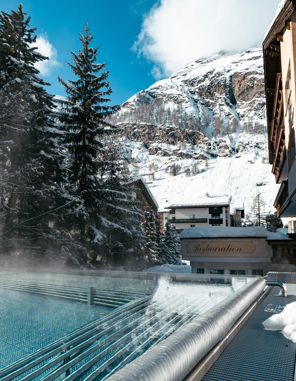 Resort La Ginabelle Zermatt: Ihr 4*S Wellnessresort in Zermatt Infinitypool mit Massagedüsen und Aussicht auf die verschneiten Berge im Winter.