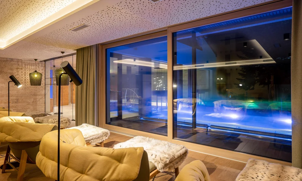 Resort La Ginabelle Zermatt: Ihr 4*S Wellnessresort in Zermatt Stimmungsvoller Ruheraum mit Liegen und Kuscheldecke mit Aussicht auf den Aussenpool.
