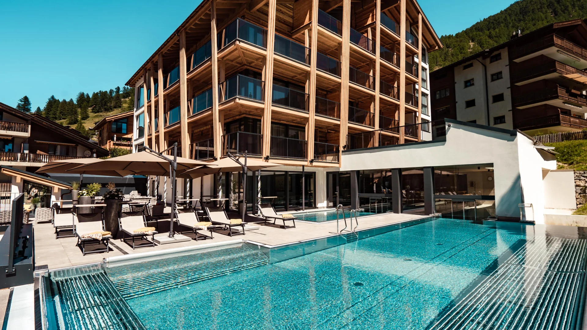 Resort La Ginabelle Zermatt: Ihr 4*S Wellnessresort in Zermatt Hotel mit Infinitypool und Terrasse im Sommer.