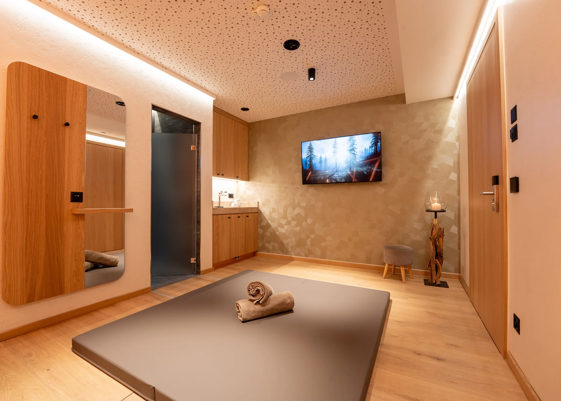 Wellnesshotel in Zermatt | GinaSPA im Resort La Ginabelle Tatami Matte in stimmungsvollem Behnaldungsraum mit Spiegel an der Wand.