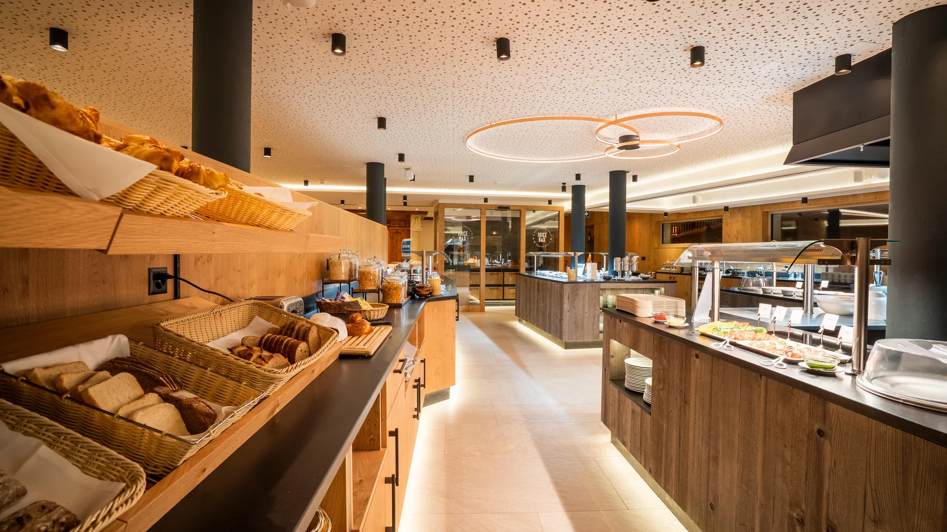 Resort La Ginabelle Zermatt: Ihr 4*S Wellnessresort in Zermatt Frühstücksbuffet mit Holzverkleidung und indirekter Beleuchtung.