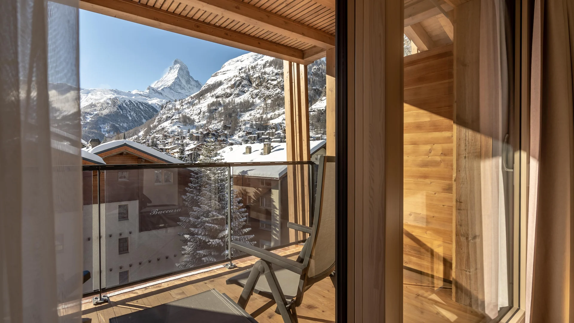 Resort La Ginabelle Zermatt: Ihr 4*S Wellnessresort in Zermatt Ausblick auf schneebedecktes Dorf und Matterhorn vom Zimmer aus